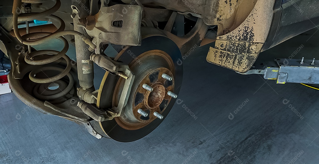 Sistema de freio a disco do carro. Suspensão do carro em processo de substituição de pneus novos na oficina de garagem.