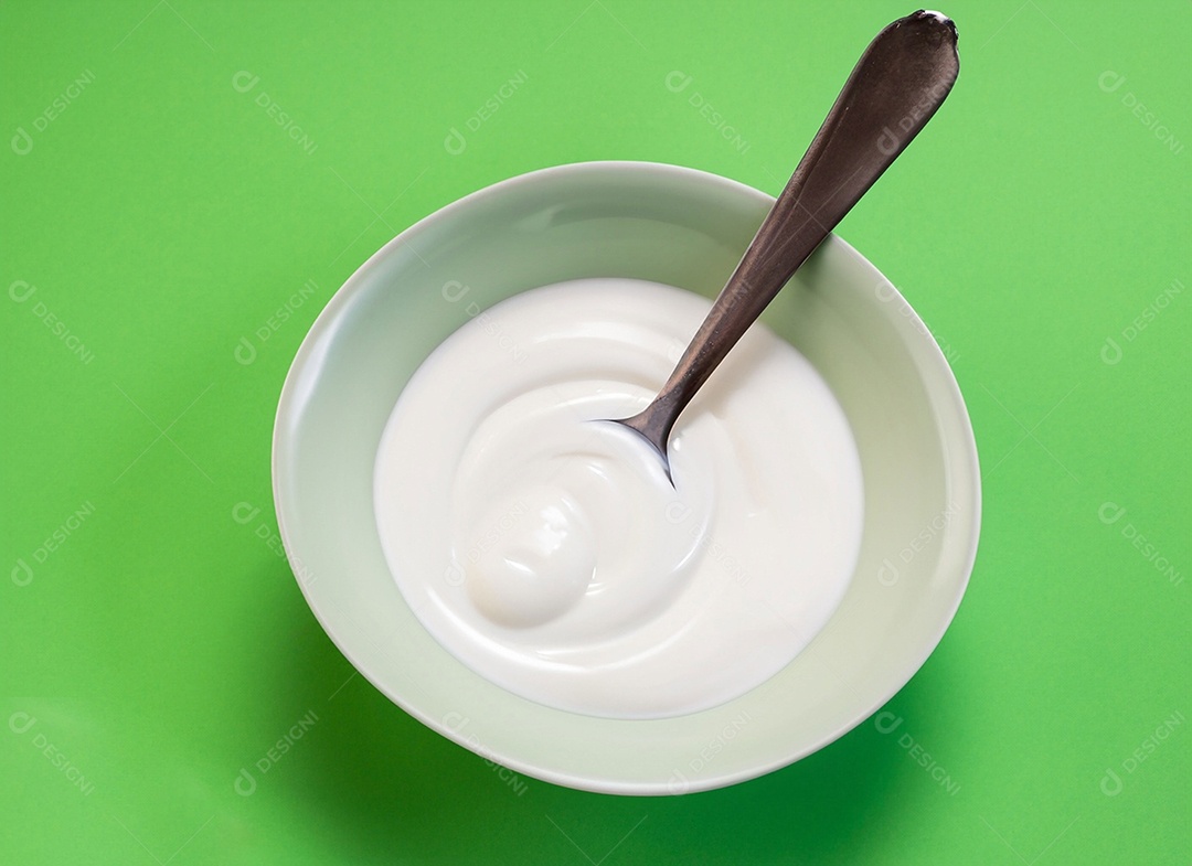 Iogurte em uma tigela no fundo verde