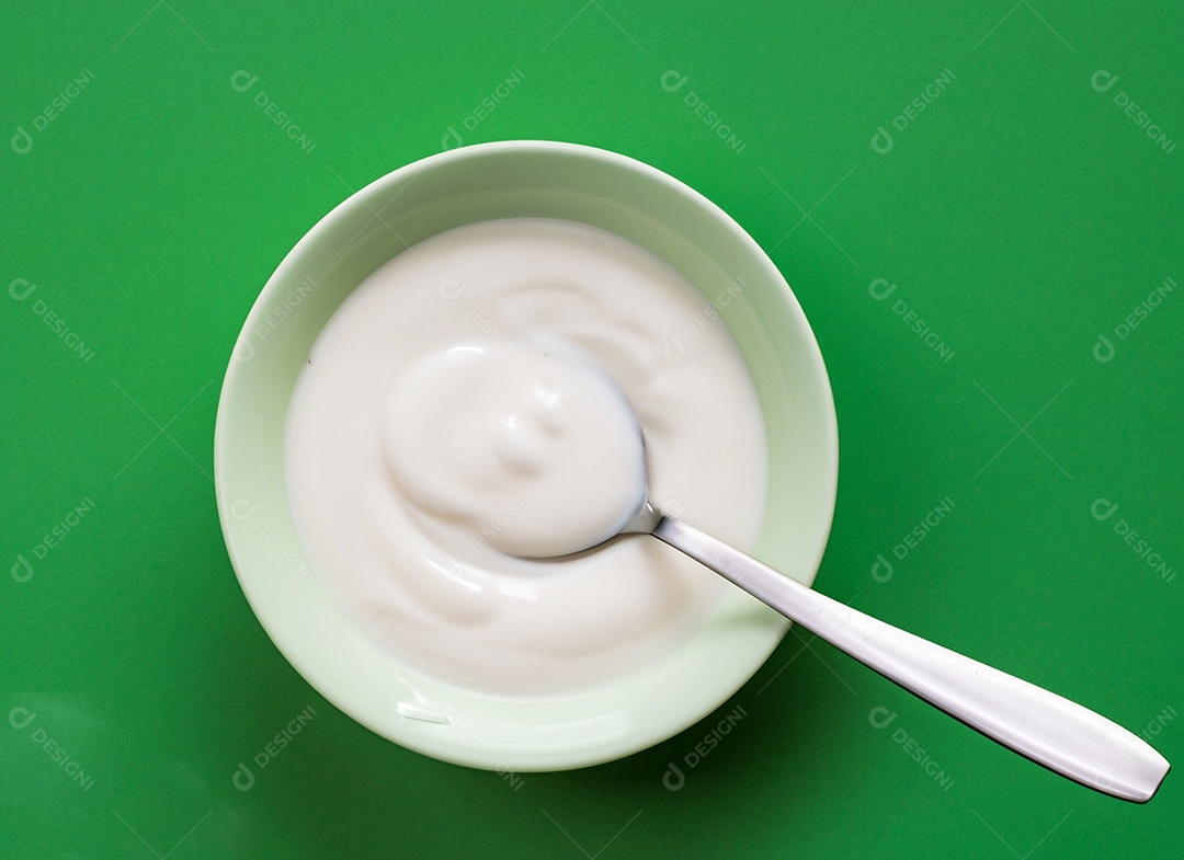 Iogurte em uma tigela no fundo verde