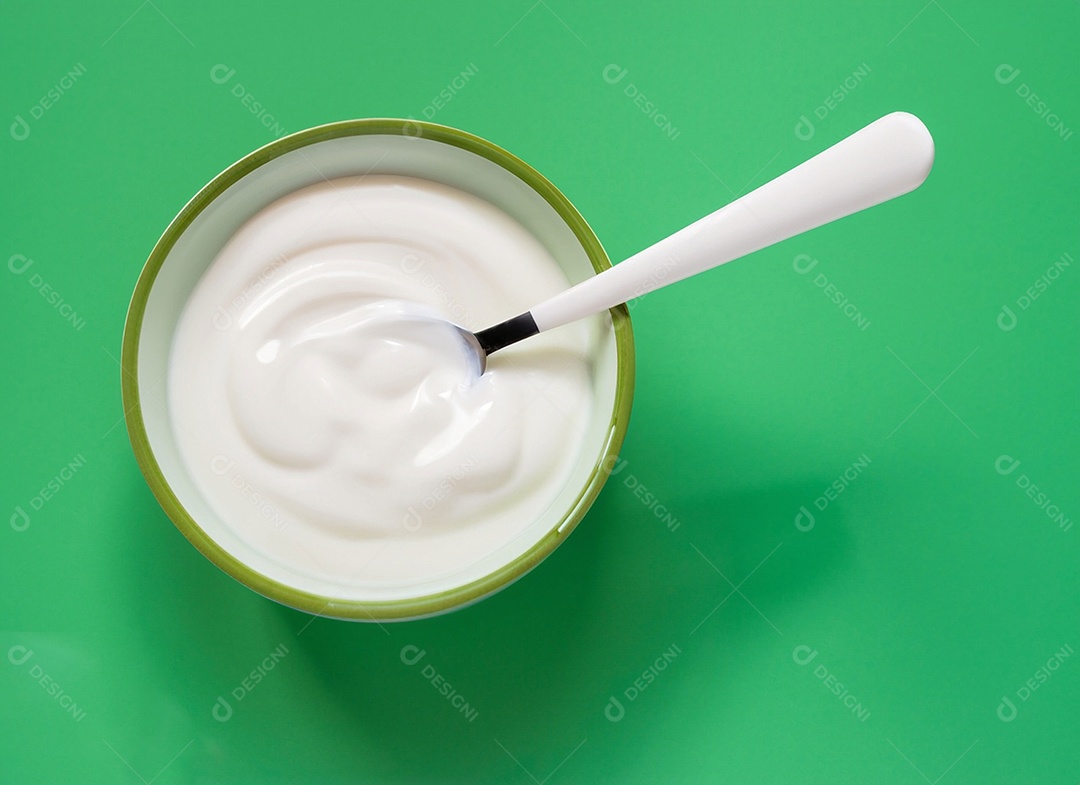 Iogurte em uma tigela no fundo verde