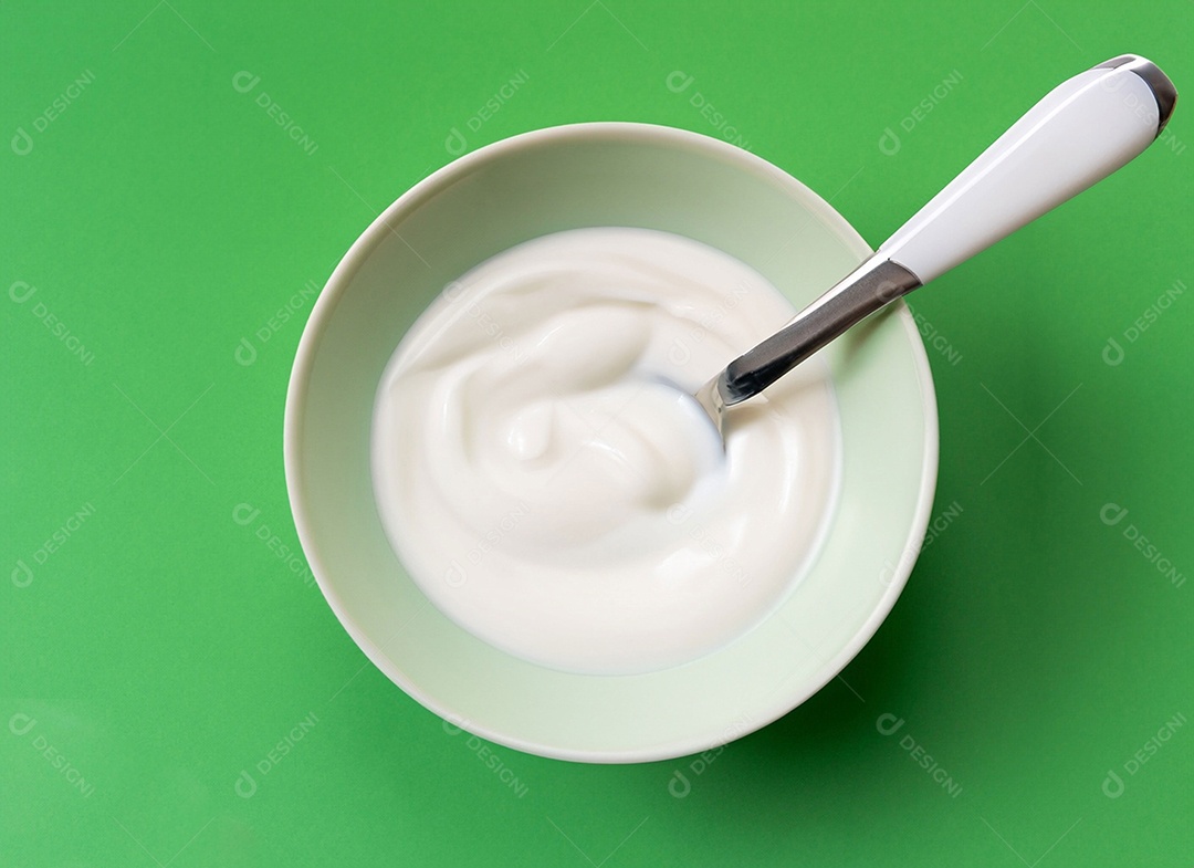 Iogurte em uma tigela no fundo verde