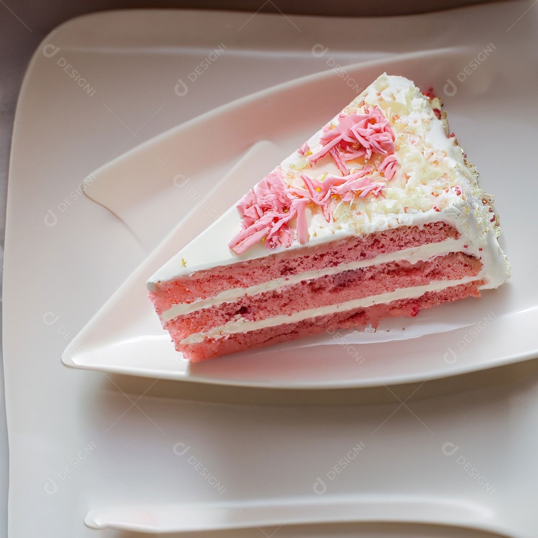 Fatia de bolo de creme rosa fresco decorada com granulado em prato branco