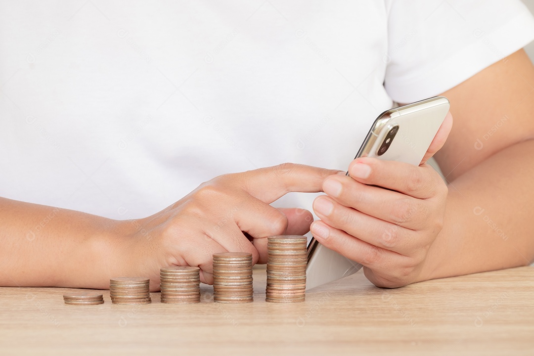 Economizando o conceito de dinheiro predefinido pela mão feminina colocando a pilha de moedas de dinheiro em crescimento