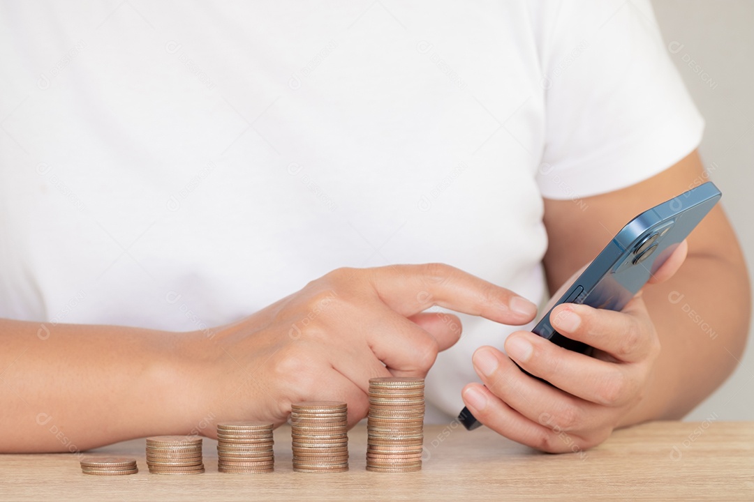 Economizando o conceito de dinheiro predefinido pela mão feminina colocando a pilha de moedas de dinheiro em crescimento