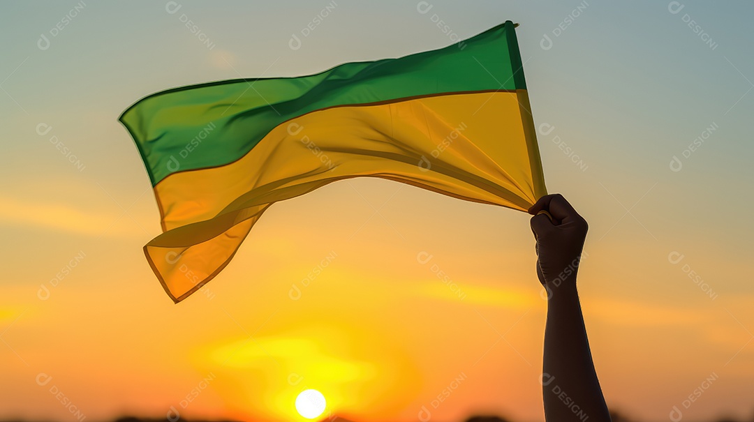 Mão segurando bandeira verde e amarela contra o céu no dia da independência do Brasil e espaçamento para texto