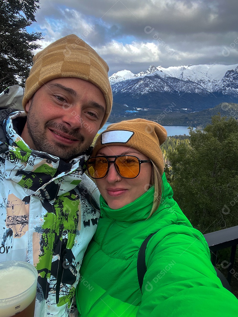 Casal feliz com trajes para o frio em uma viagem linda.