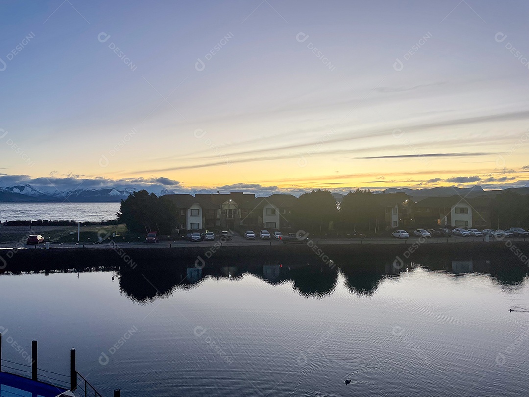 Casas e carrros na beira do rio.