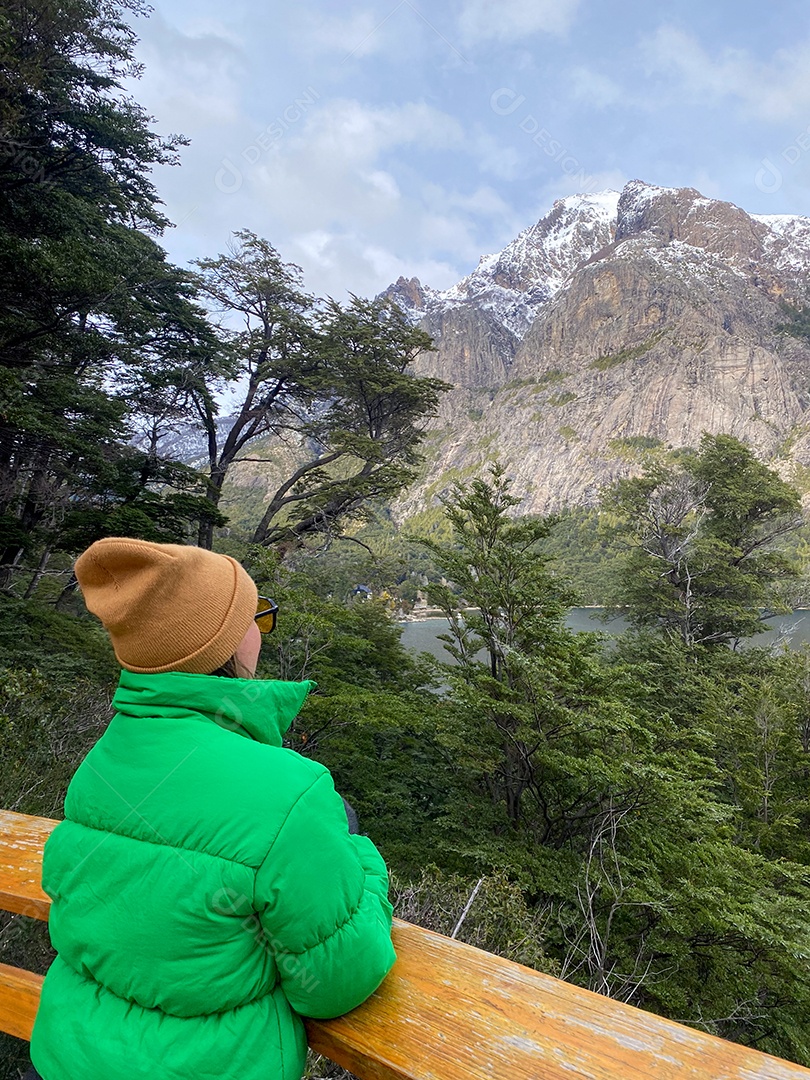 Uma mulher feliz e estilosa olhando paisagem.