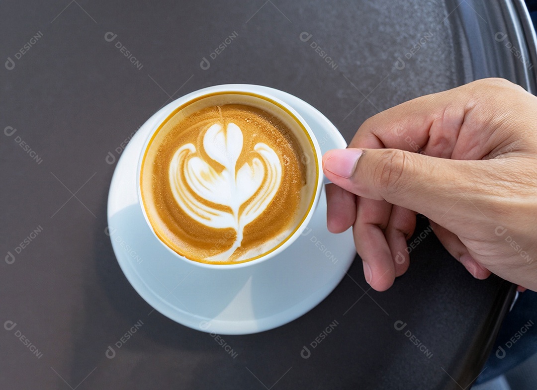 Mão segurando uma xícara de café com leite Dia internacional do café