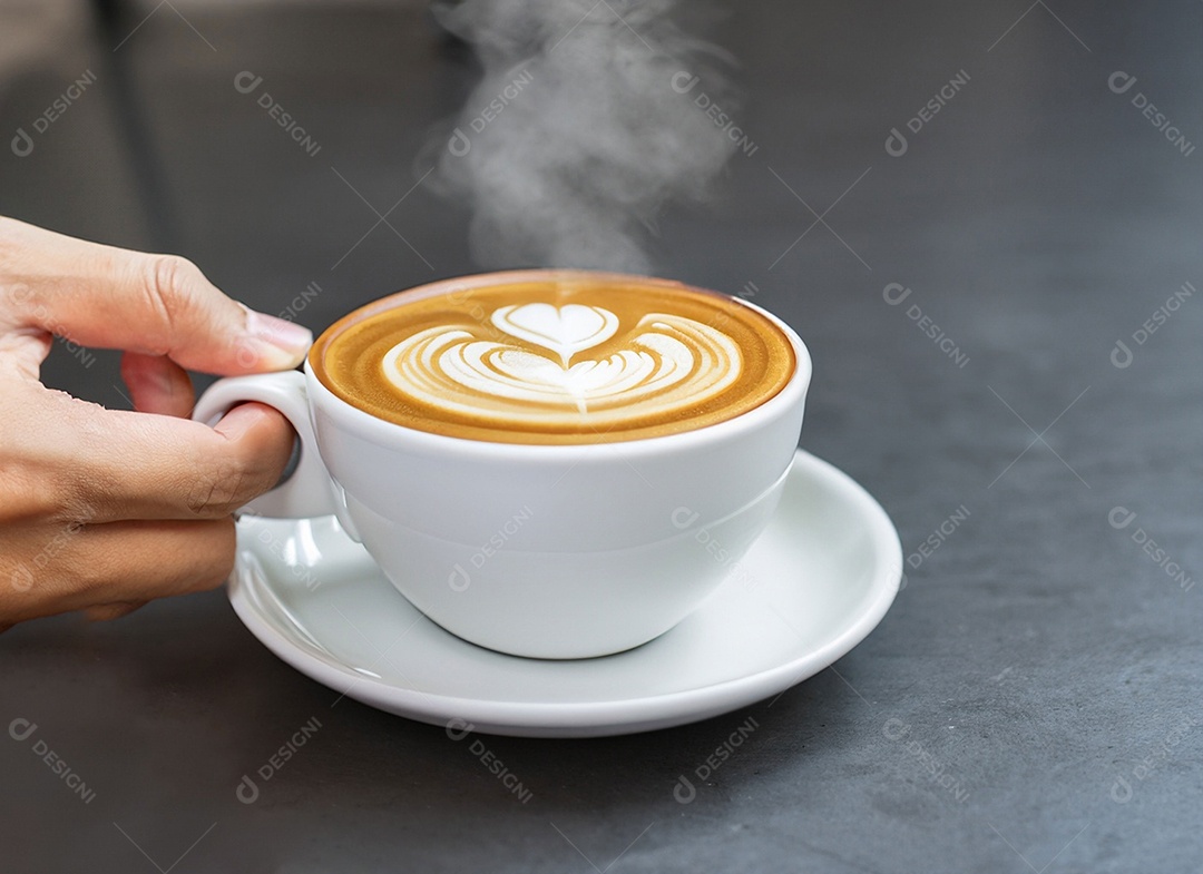 Mão segurando uma xícara de café com leite Dia internacional do café