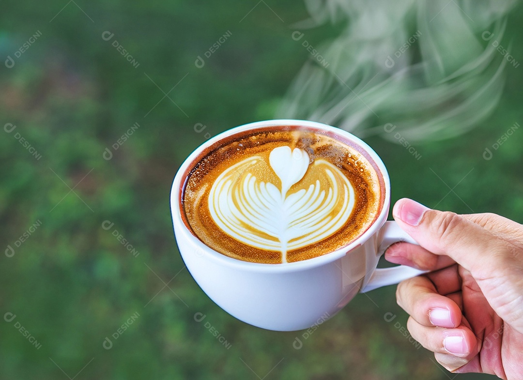 Mão segurando uma xícara de café com leite Dia internacional do café