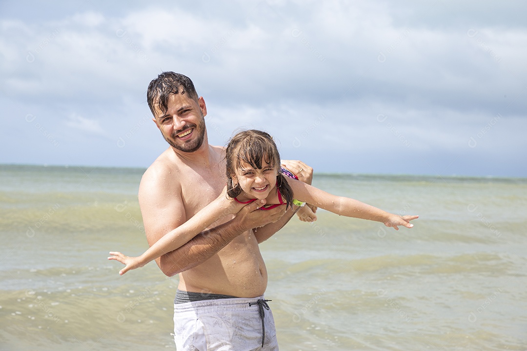 Homem e menina brincando na praia