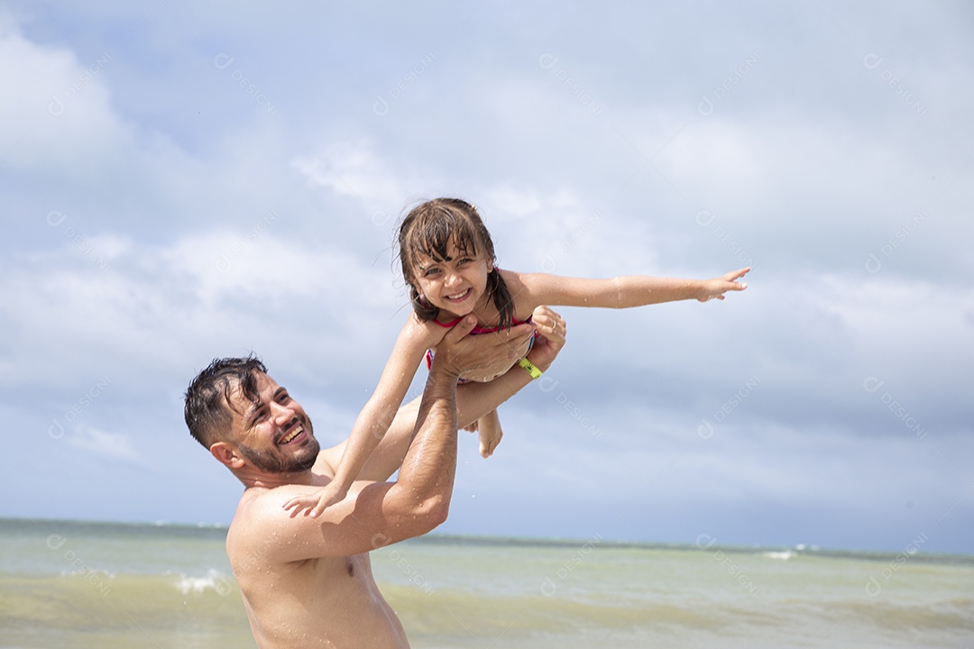 Homem e menina brincando na praia