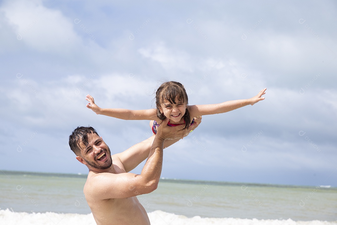 Homem e menina brincando na praia