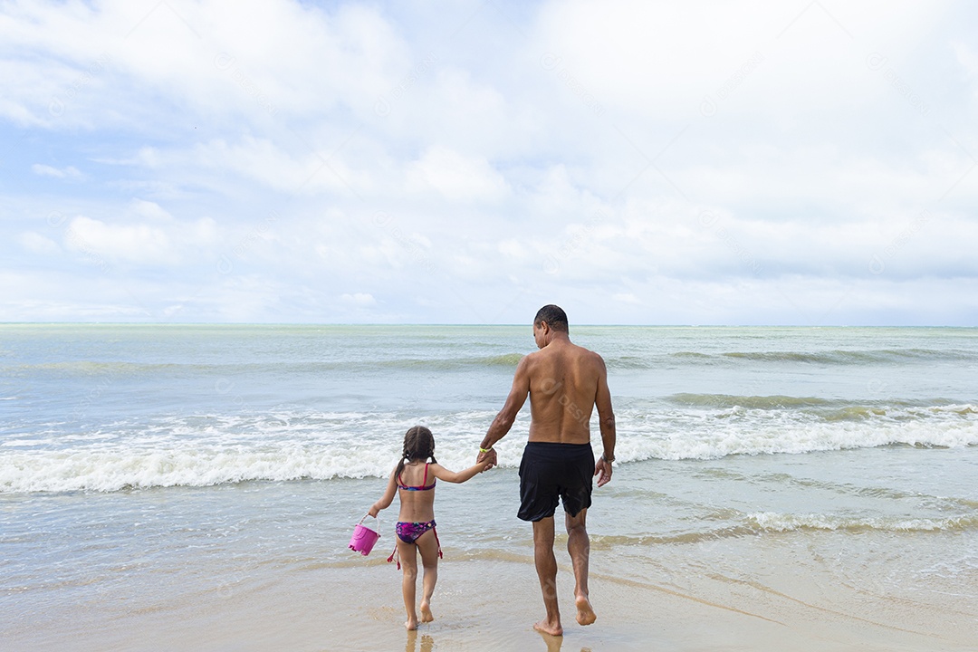 Homem e menina felizes na praia