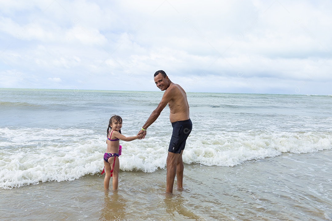 Homem e menina felizes na praia