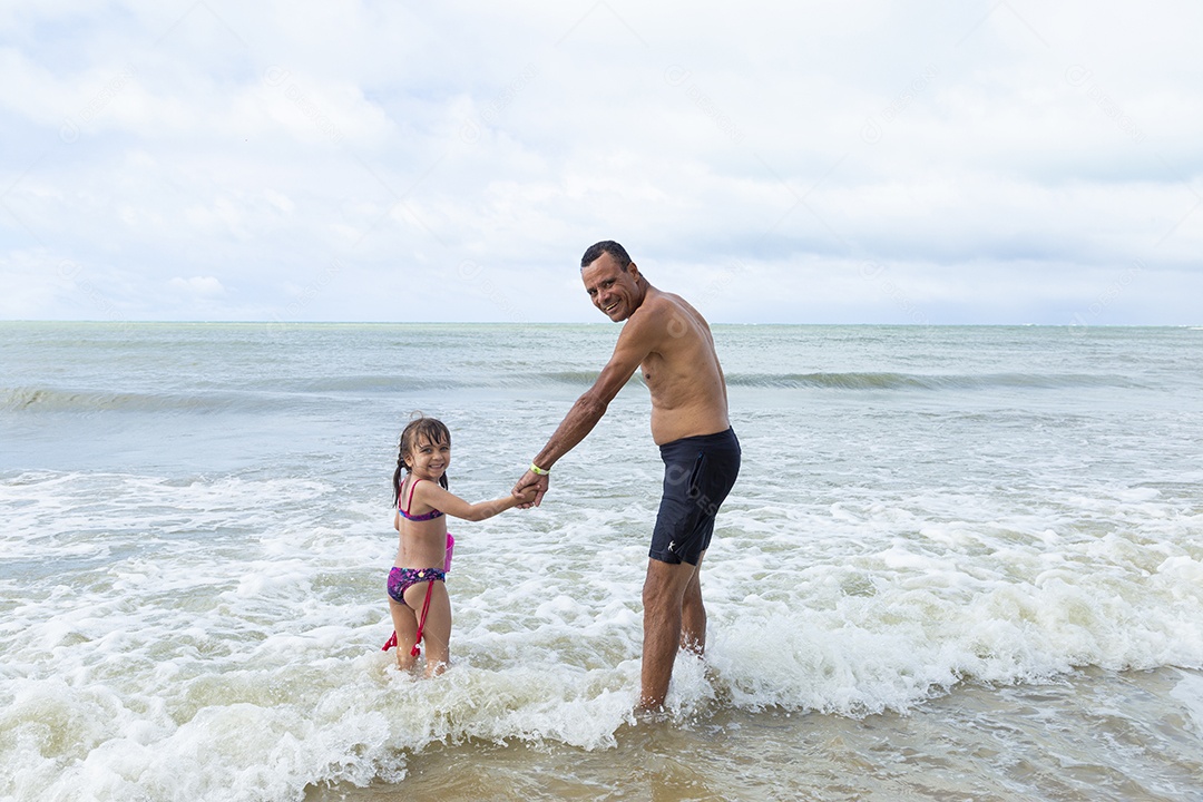 Homem e menina felizes na praia