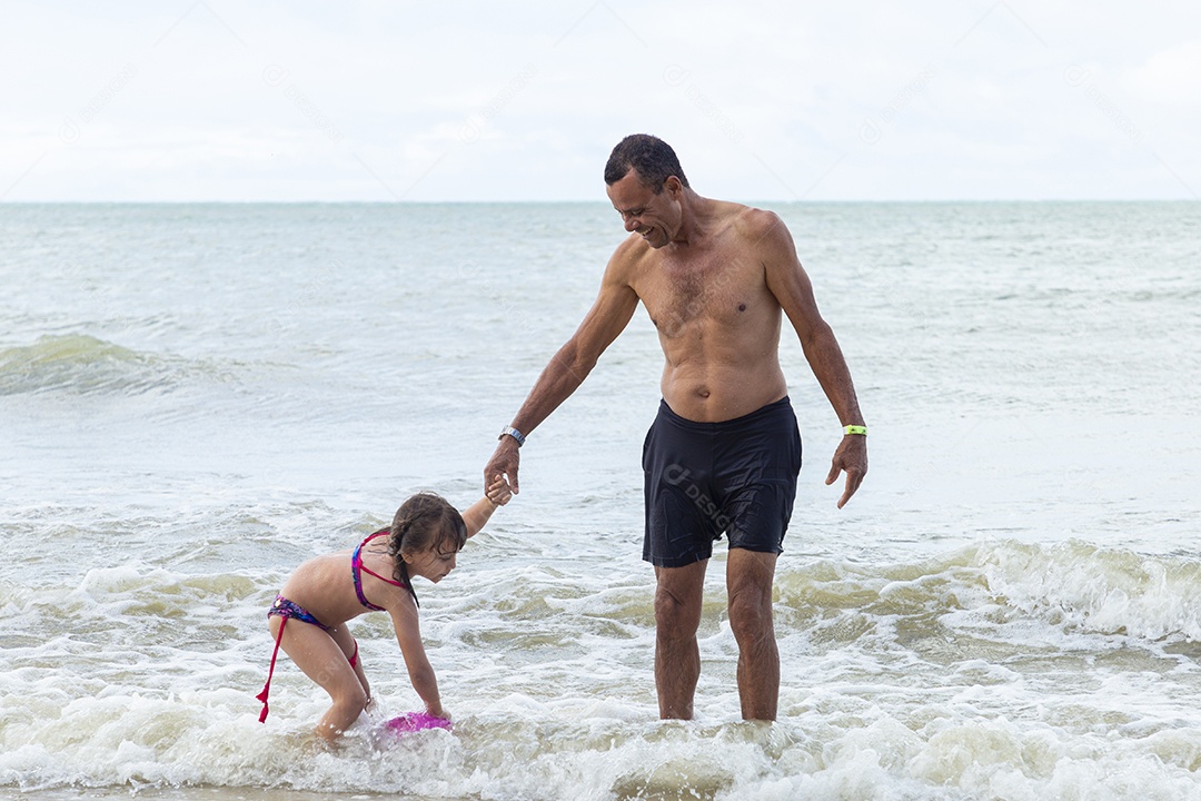 Homem e menina felizes na praia