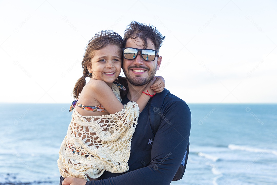 Pai e filha sorridentes na praia