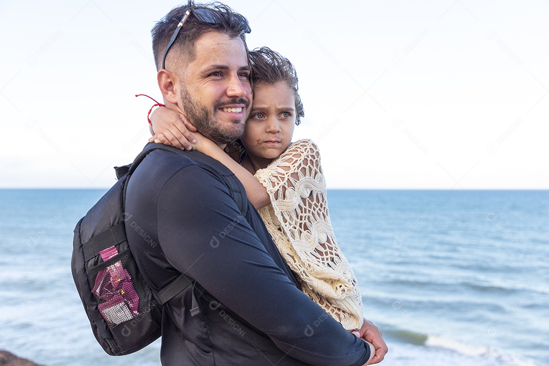 Pai e filha sorridentes na praia