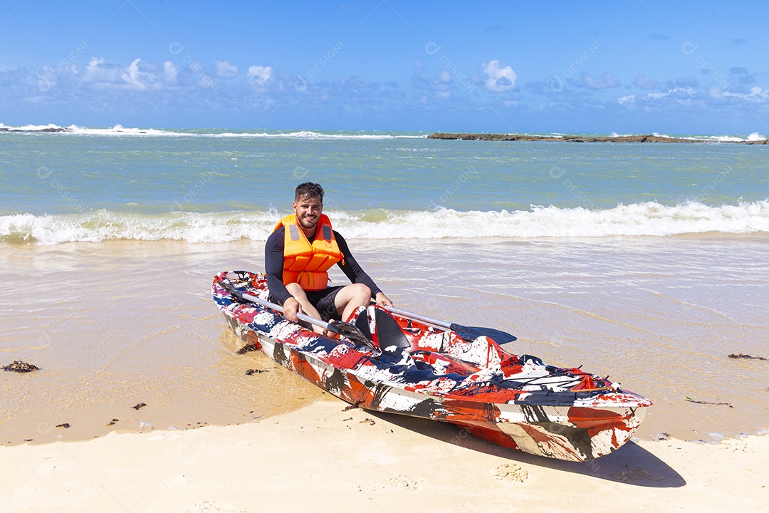 Homem andando de caiaque na praia
