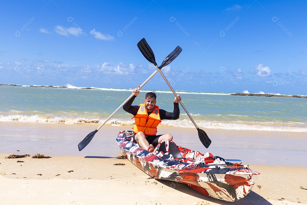 Homem andando de caiaque na praia