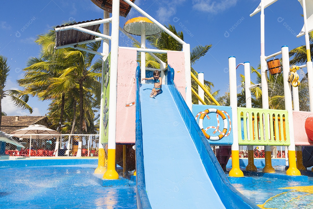 Linda garotinha brincando no tobogã do parque de diversões