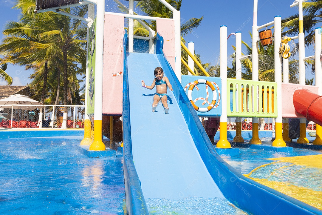 Linda garotinha brincando no tobogã do parque de diversões