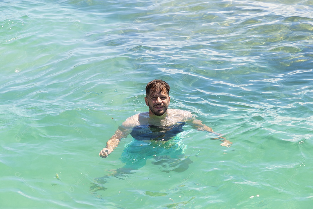 Homem sorridente mergulhando na praia