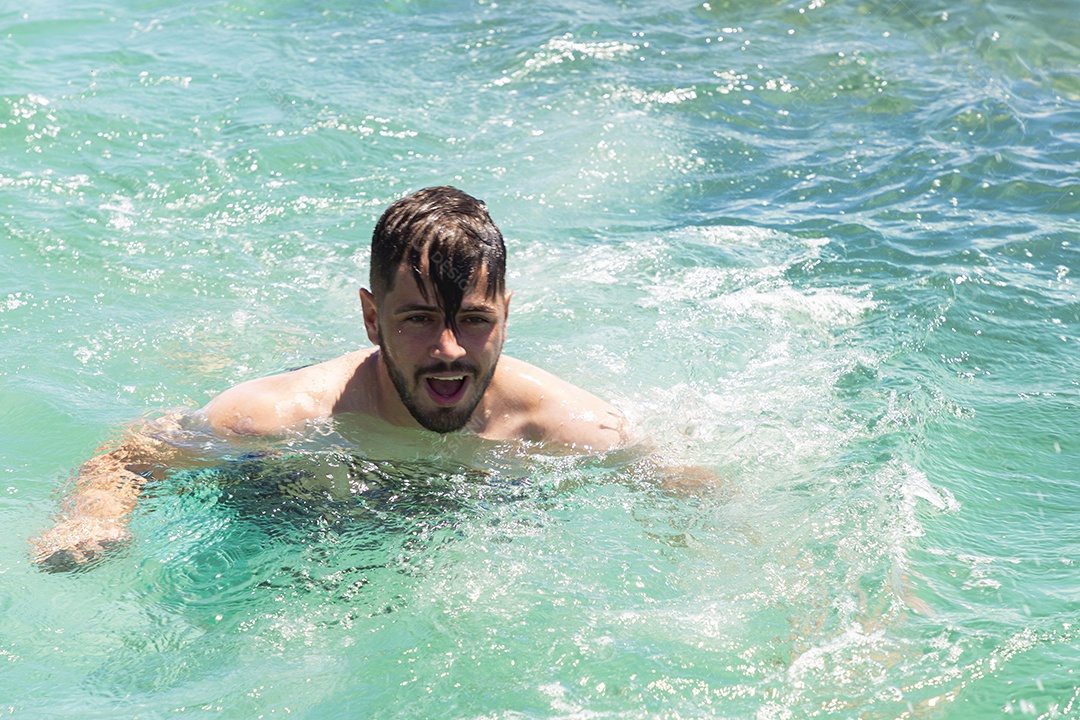 Homem sorridente mergulhando na praia