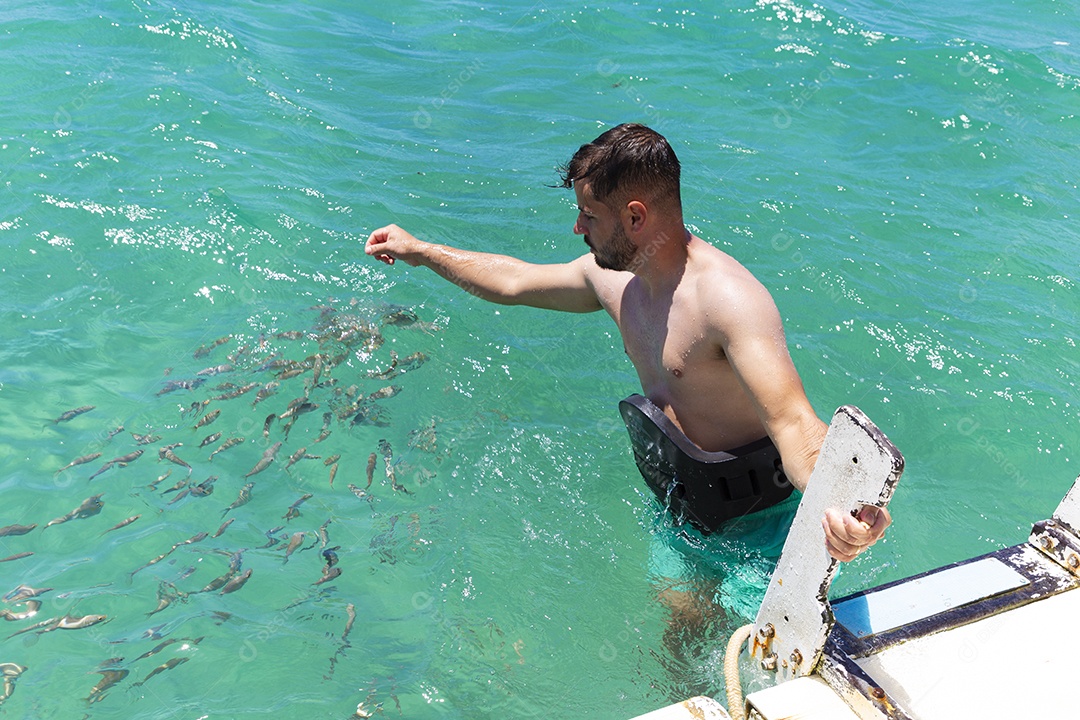 Homem sorridente mergulhando na praia