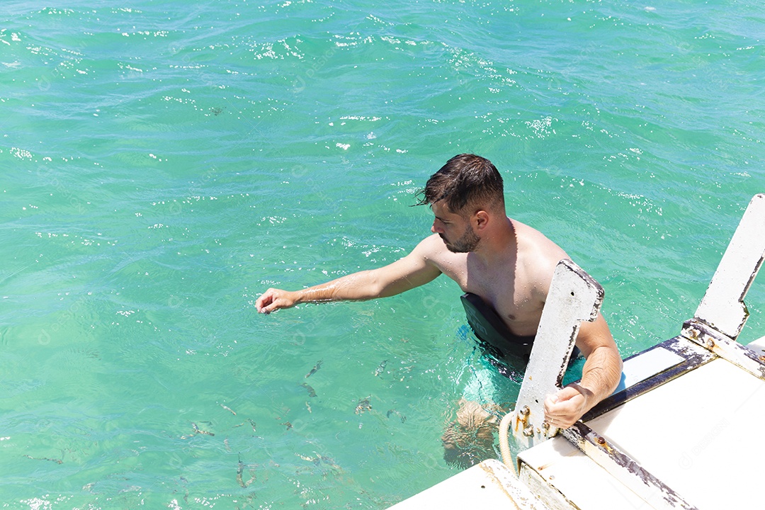 Homem sorridente mergulhando na praia