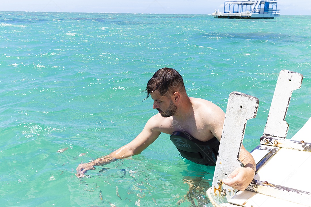 Homem sorridente mergulhando na praia