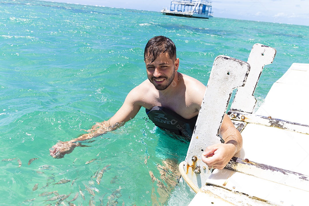 Homem sorridente mergulhando na praia