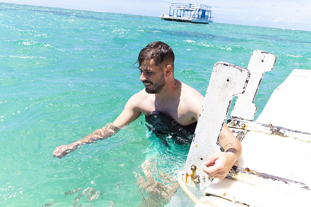 Homem sorridente mergulhando na praia