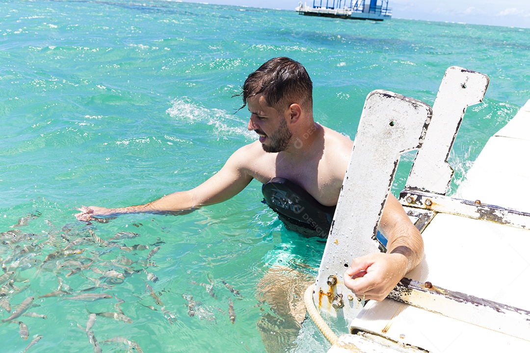 Homem sorridente mergulhando na praia