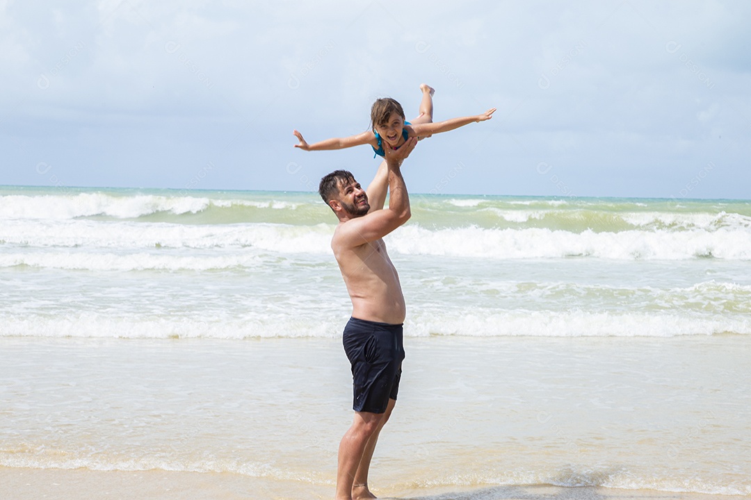 Pai e filha brincando na praia