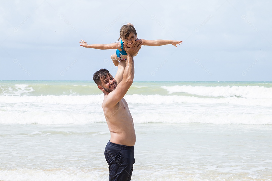 Pai e filha brincando na praia
