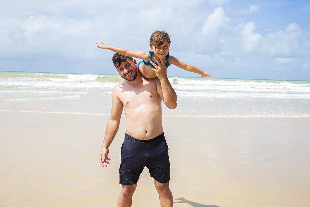 Pai e filha brincando na praia