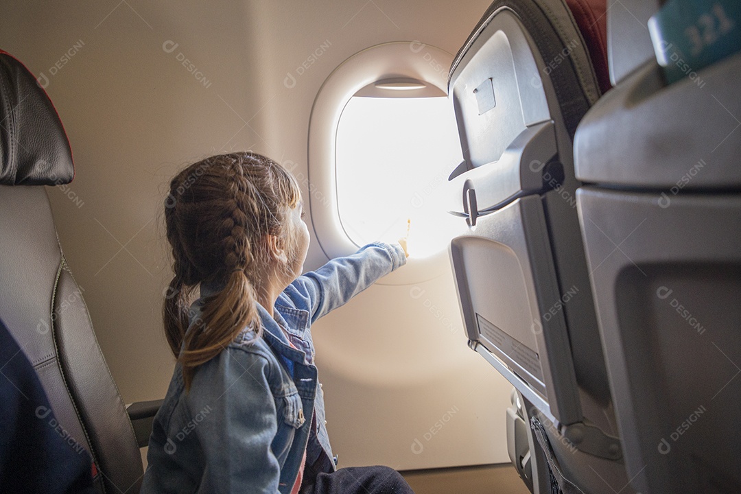 Linda menina sentada no banco do avião