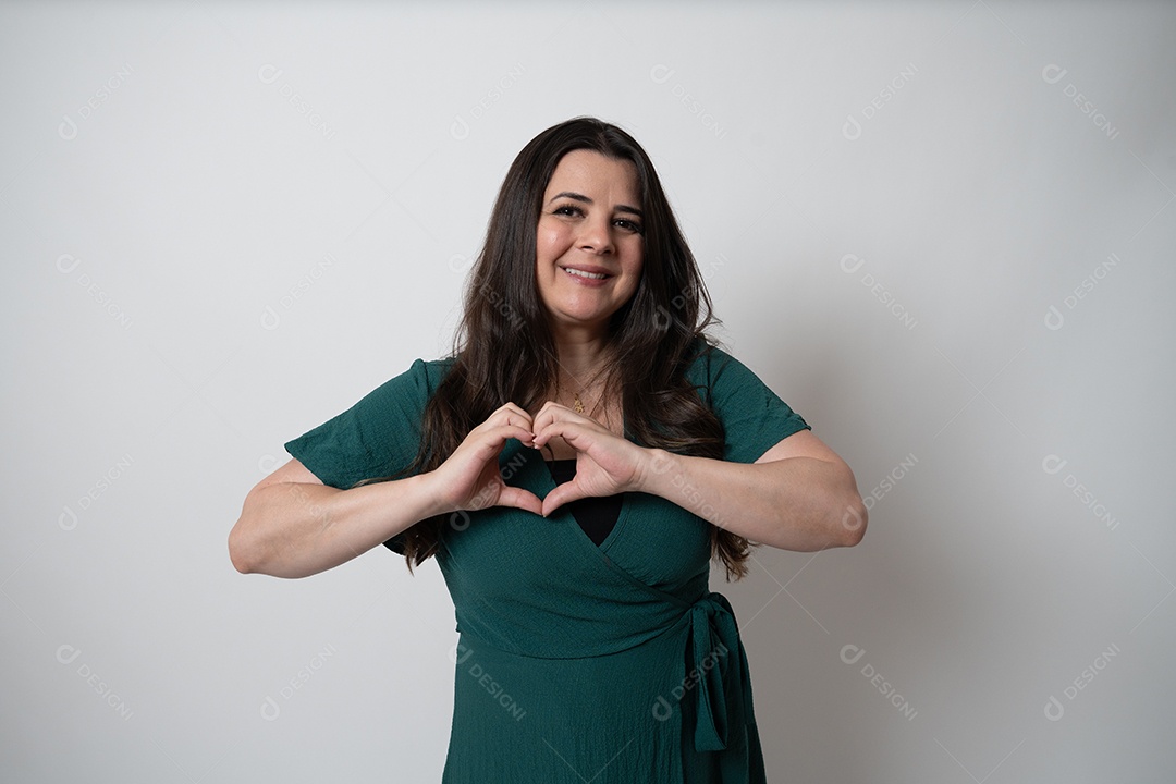 Mulher de cabelos castanhos em vestido elegante, posando para a câmera em estúdio.