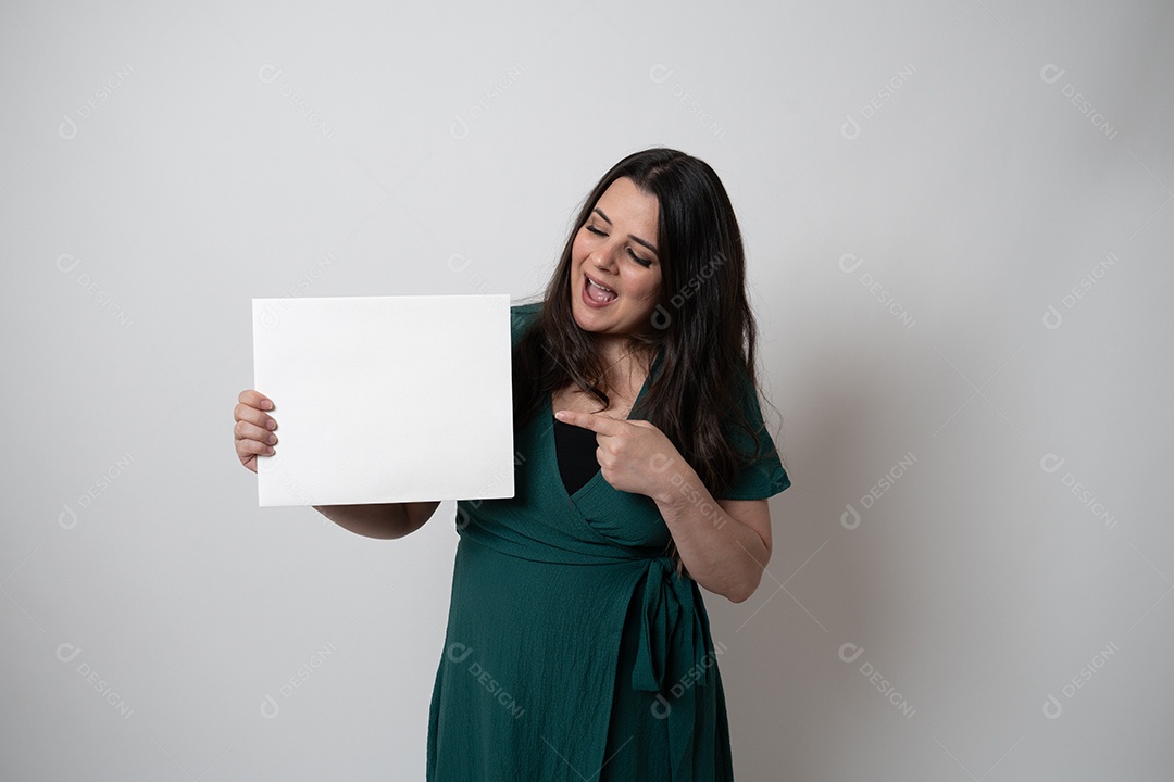 Mulher de cabelos castanhos em vestido elegante, posando para a câmera em estúdio.