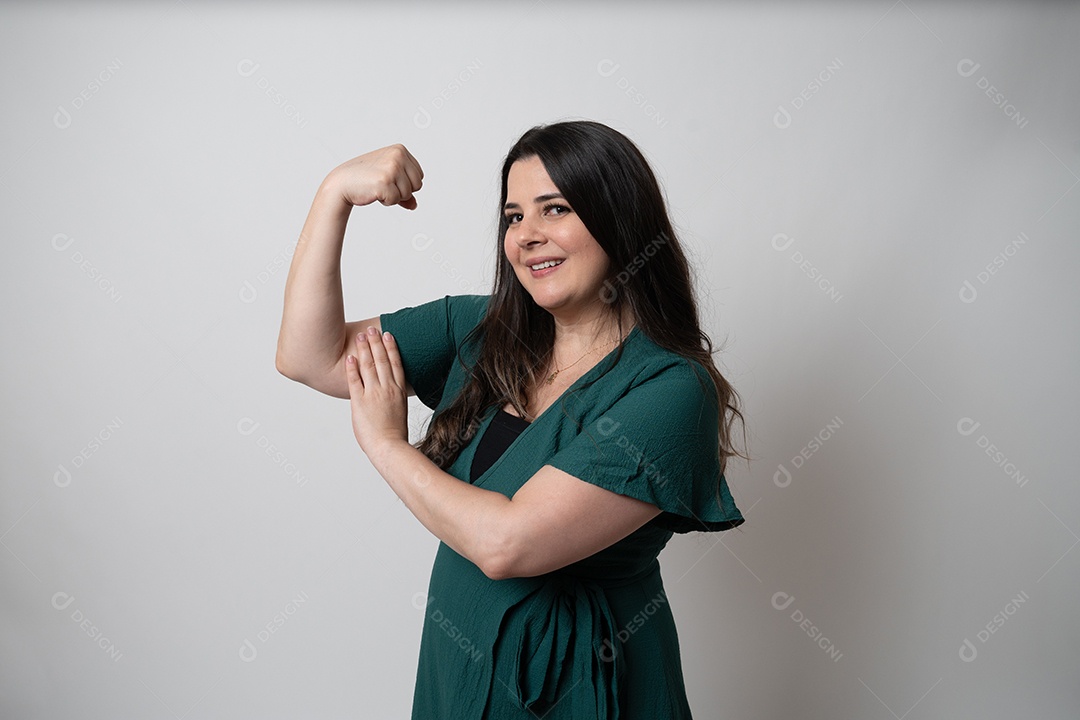 Mulher de cabelos castanhos em vestido elegante, posando para a câmera em estúdio.