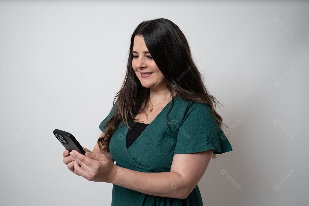 Mulher de cabelos castanhos em vestido elegante, posando para a câmera em estúdio.