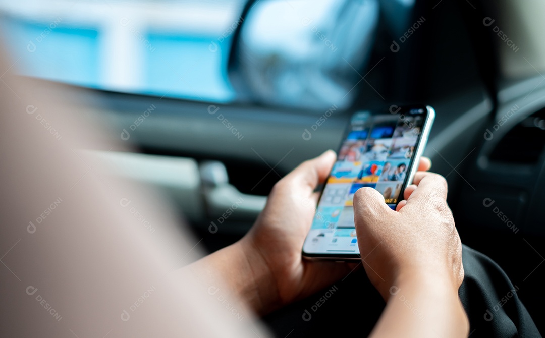 Mão de uma mulher usando smartphone enquanto está sentado no carro para entretenimento durante engarrafamentos ou durante uma longa viagem