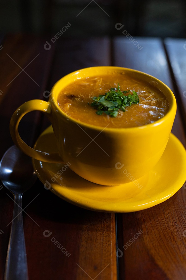 Xícara de sopa de lentilha sobre uma mesa de madeira