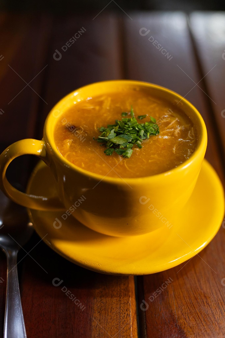 Xícara de sopa de lentilha sobre uma mesa de madeira
