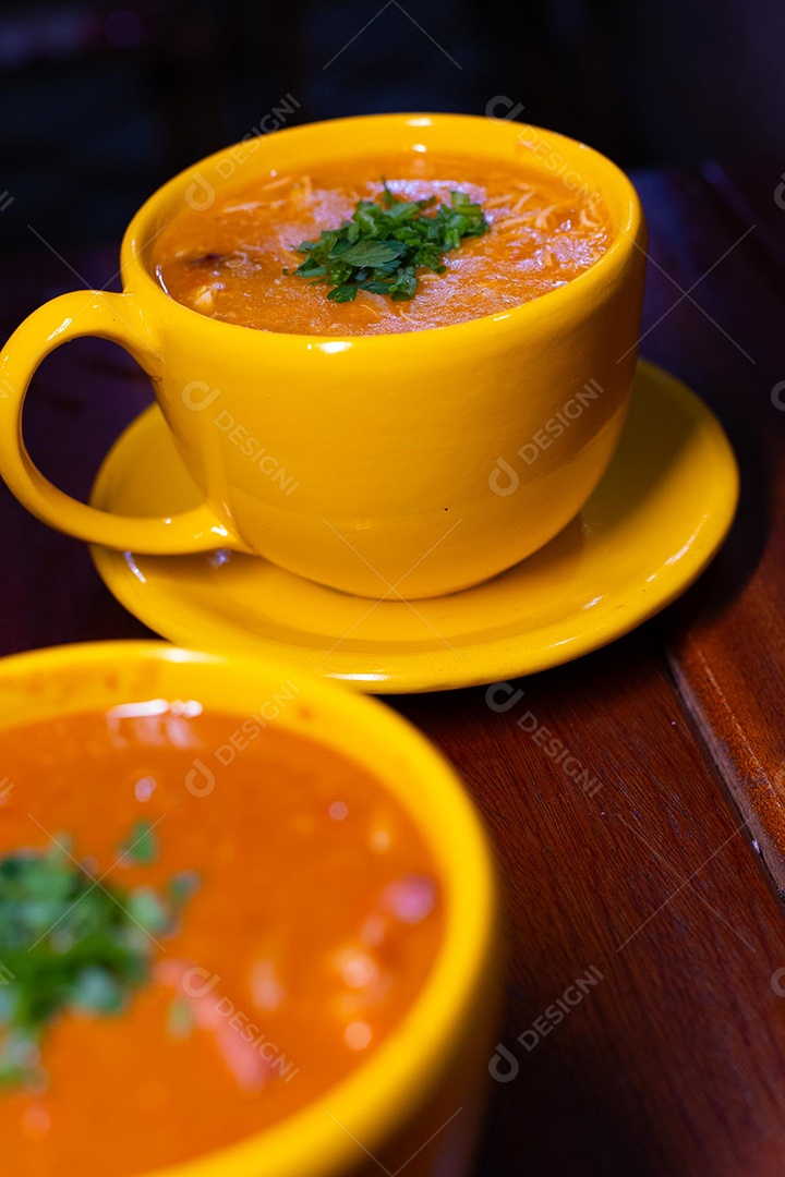 Xícara de sopa de lentilha sobre uma mesa de madeira