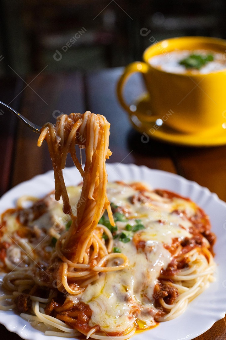 Um prato de espaguete gratinado com queijo