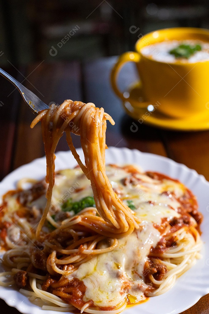 Um prato de espaguete gratinado com queijo